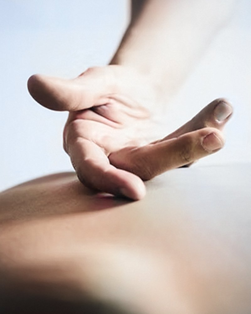 Close up of Tui-Na practitioner's hand with palm up moving across a patient's back